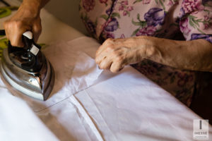 Mamma dello sposo che stira la camicia del figlio