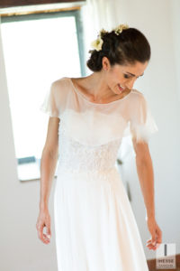 La sposa sorride e guarda il vestito indossato